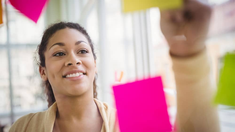 Mulher fazendo anotações com post-it