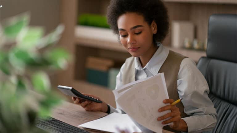 Mulher fazendo contabilidade da sua empresa e analisando impostos
