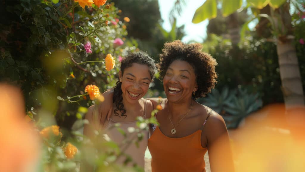 Duas mulheres sorrindo entre flores amarelas, simbolizando acolhimento, conexão e a campanha Setembro Amarelo pela valorização da vida e saúde emocional.