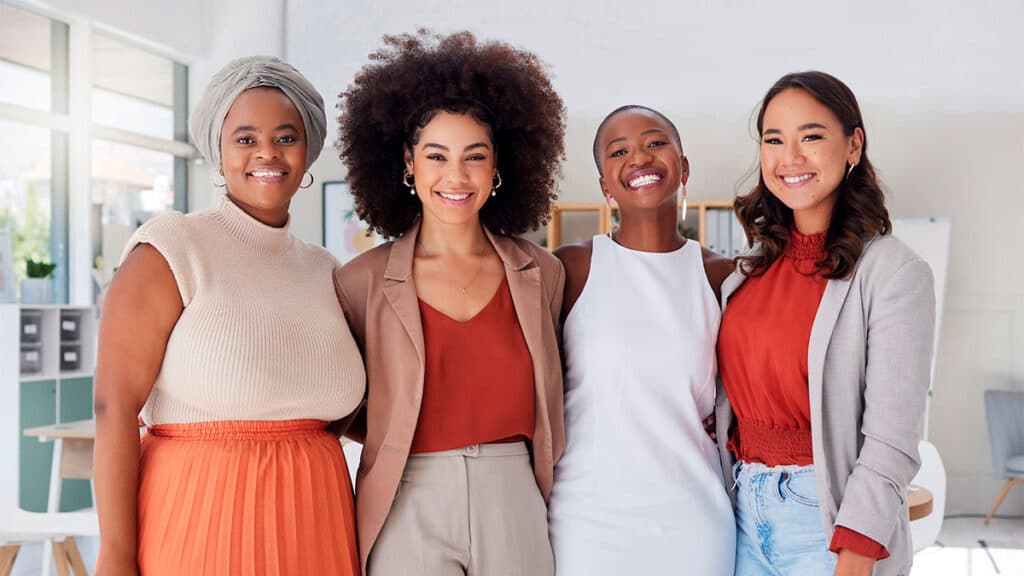 Grupo de mulheres sorridentes em ambiente de trabalho, representando empreendedoras de sucesso que inspiram com suas histórias e conquistas profissionais.